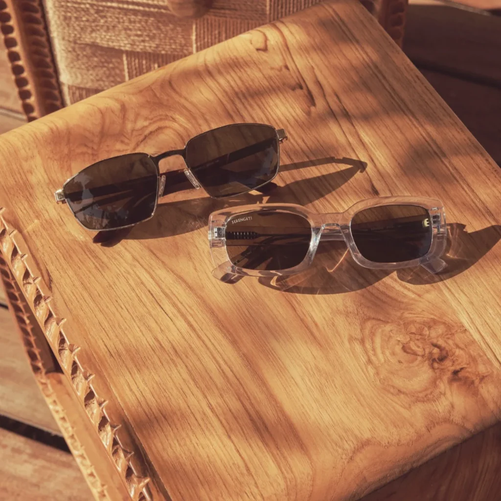 Twee Serengeti zonnebrillen met donkere glazen op houten tafel bij Teeling Optiek