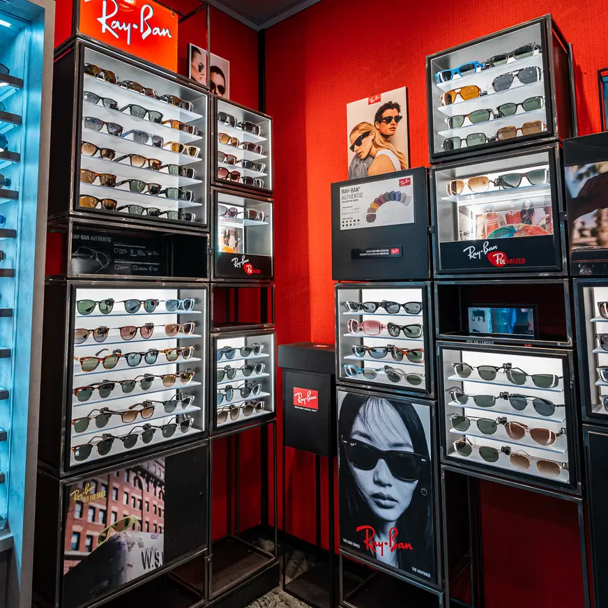 Een uitgebreide wanddisplay met diverse Ray-Ban modellen in een optiekzaak in Amsterdam, passend bij stijladvies voor 2026.